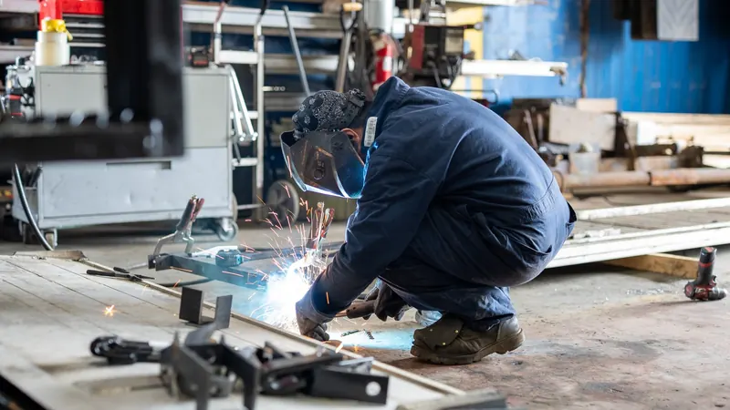 Welder working on a truck body frame