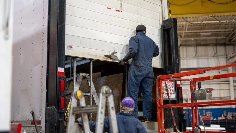 Technician repairing a roll-up rear door