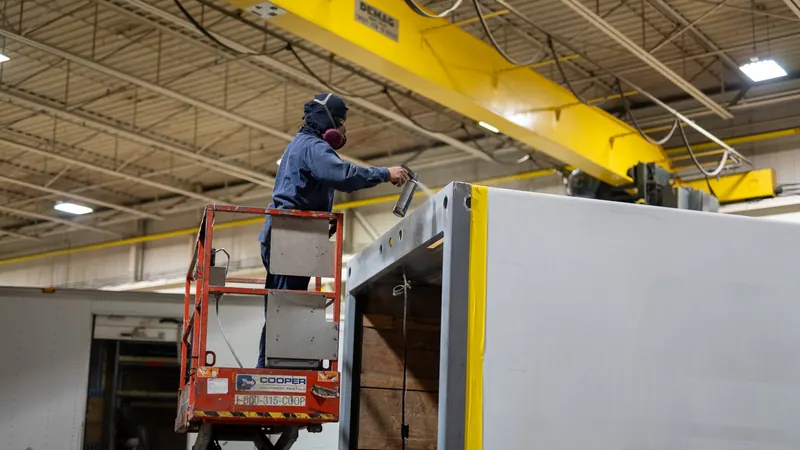 Technician on a scissor lift repairing a van body